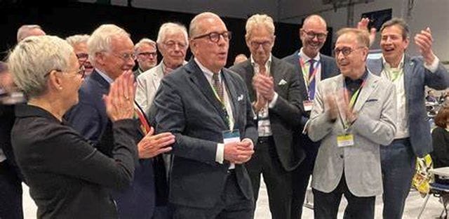 Das Foto zeigt Dr. Klaus Reinhardt im Kreis von Kolleginnen und Kollegen, als er das Ergebnis seiner Wiederwahl zum BÄK-Präsidenten erfährt.
